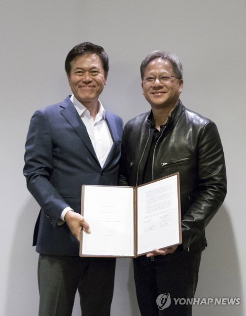 박정호 SK텔레콤 사장(왼쪽)과 젠슨 황 엔비디아 CEO가 11일(현지시간) 미국 산 호세에서 자율주행차 공동 프로젝트 관련 전략적 협약을 체결하고 있다.  SK텔레콤 제공